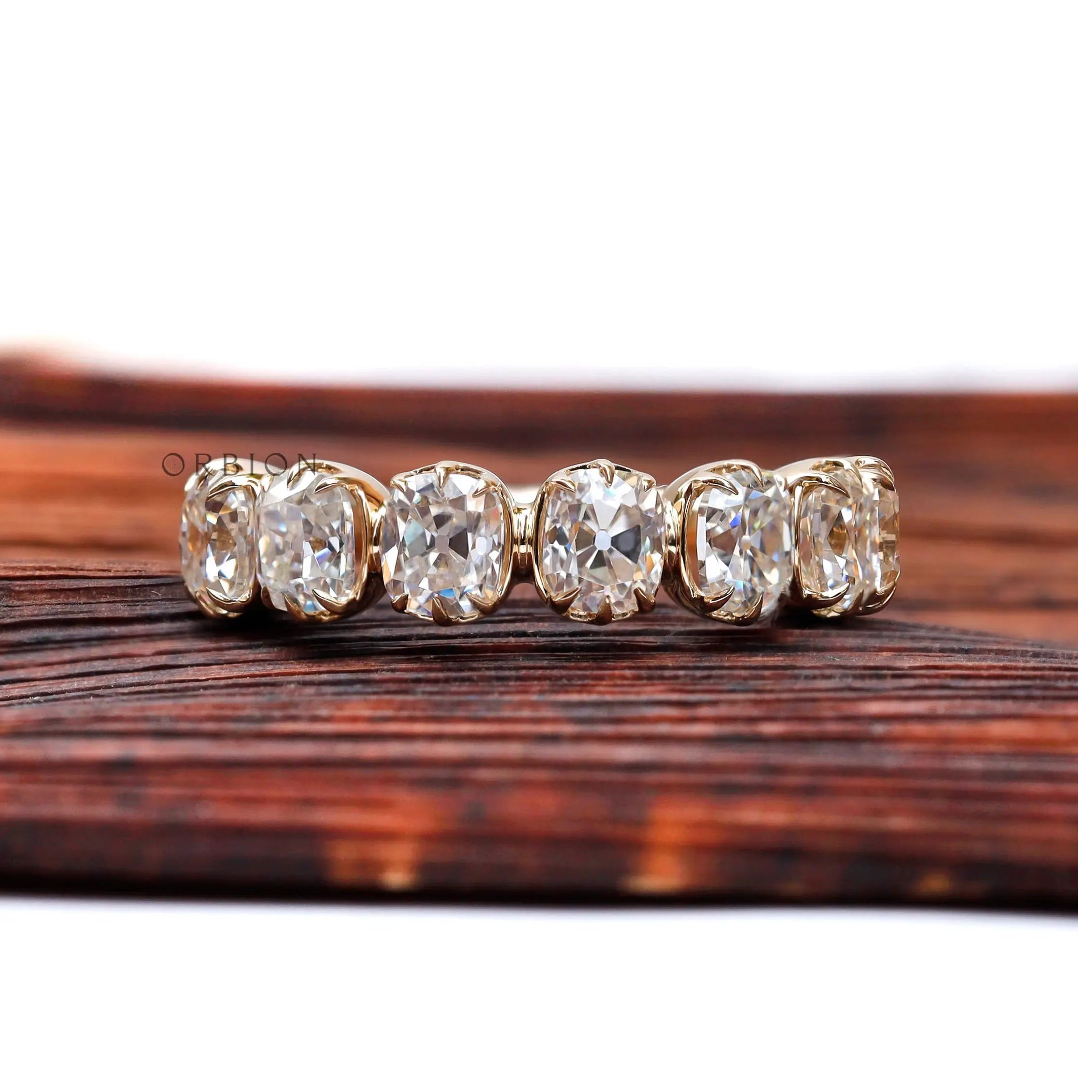 Front view of 7 stone half eternity wedding band in yellow gold with vintage prong setting