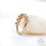 Three-quarter view of 7 stone half eternity ring highlighting vintage crown-style prongs and sparkle