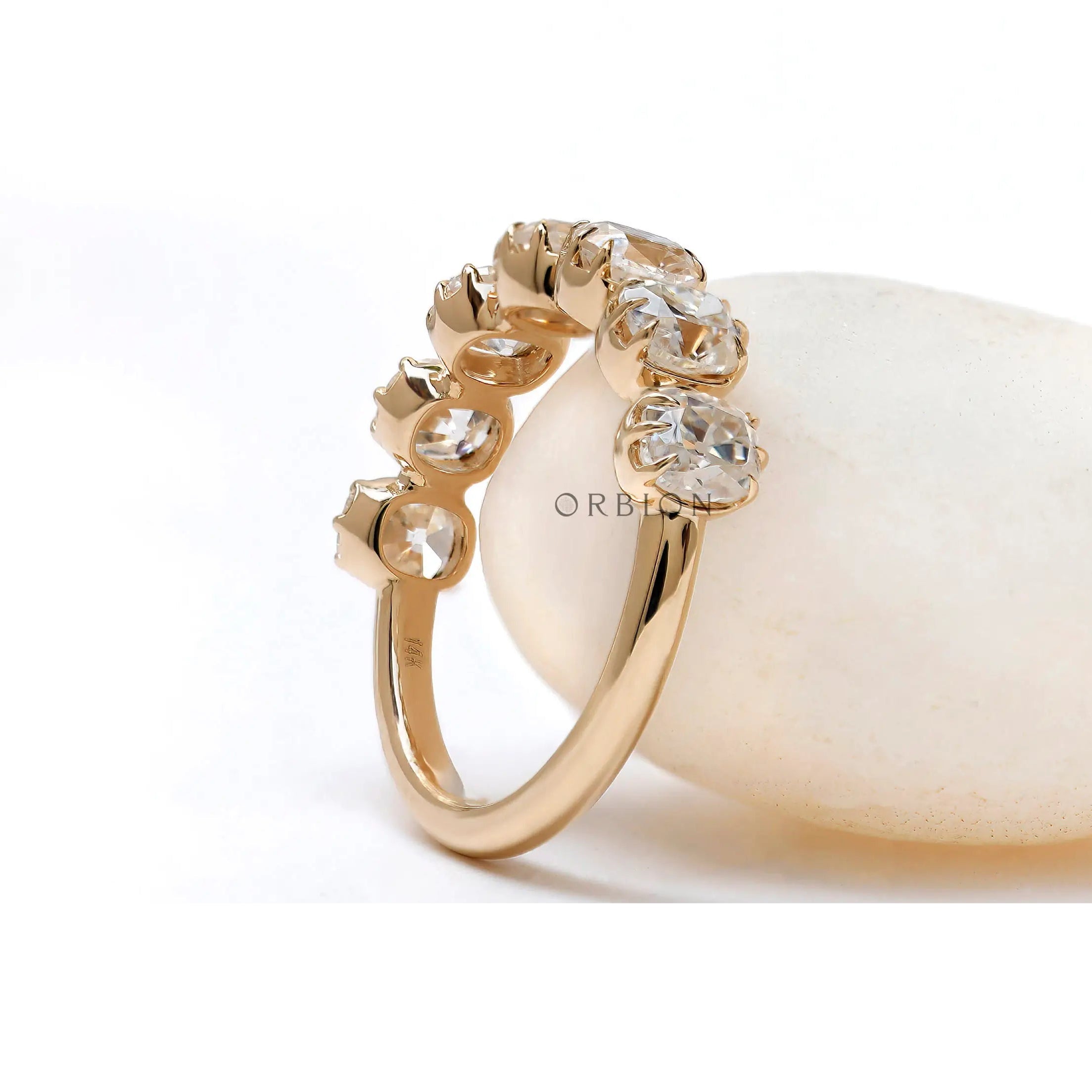Three-quarter view of 7 stone half eternity ring highlighting vintage crown-style prongs and sparkle