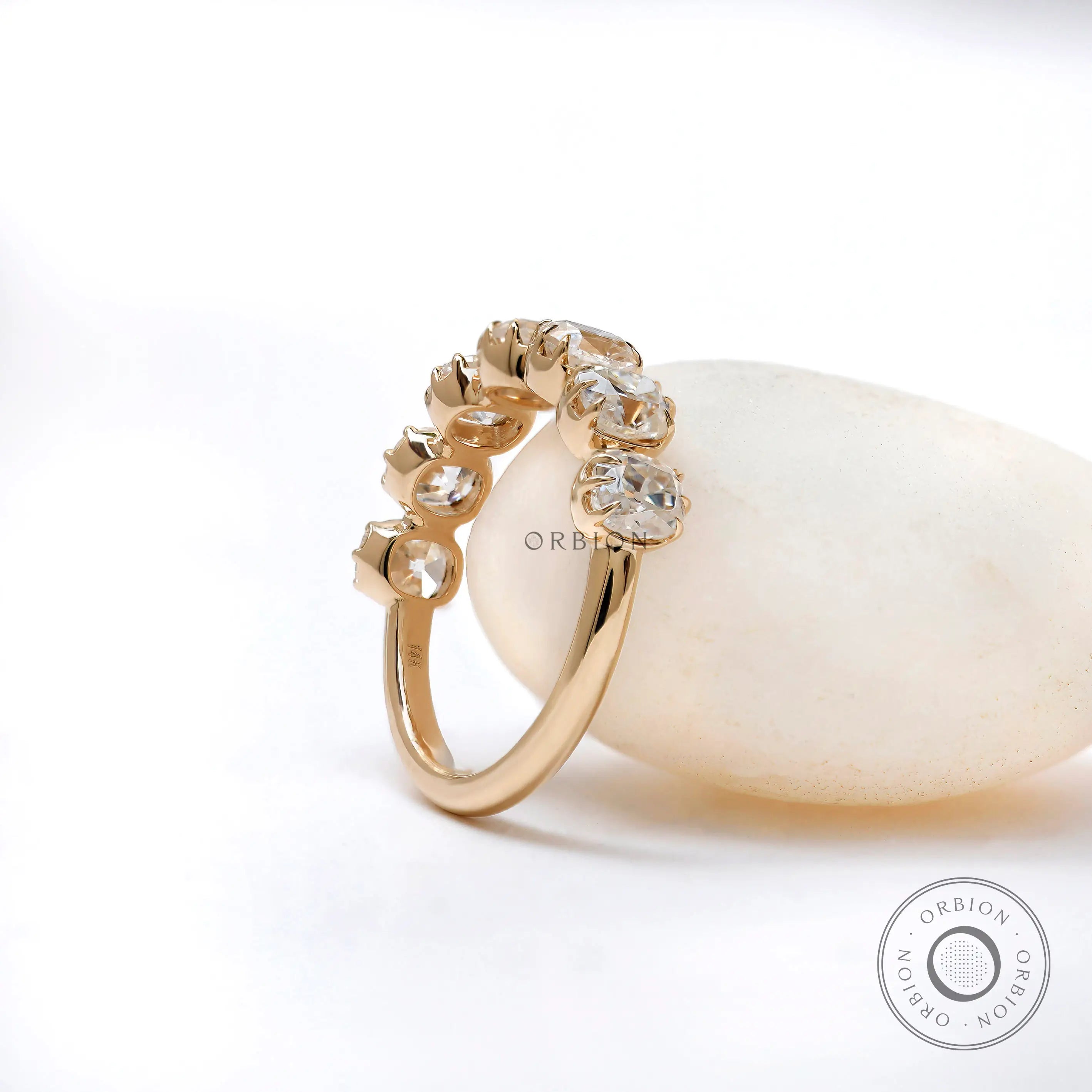 Three-quarter view of 7 stone half eternity ring highlighting vintage crown-style prongs and sparkle