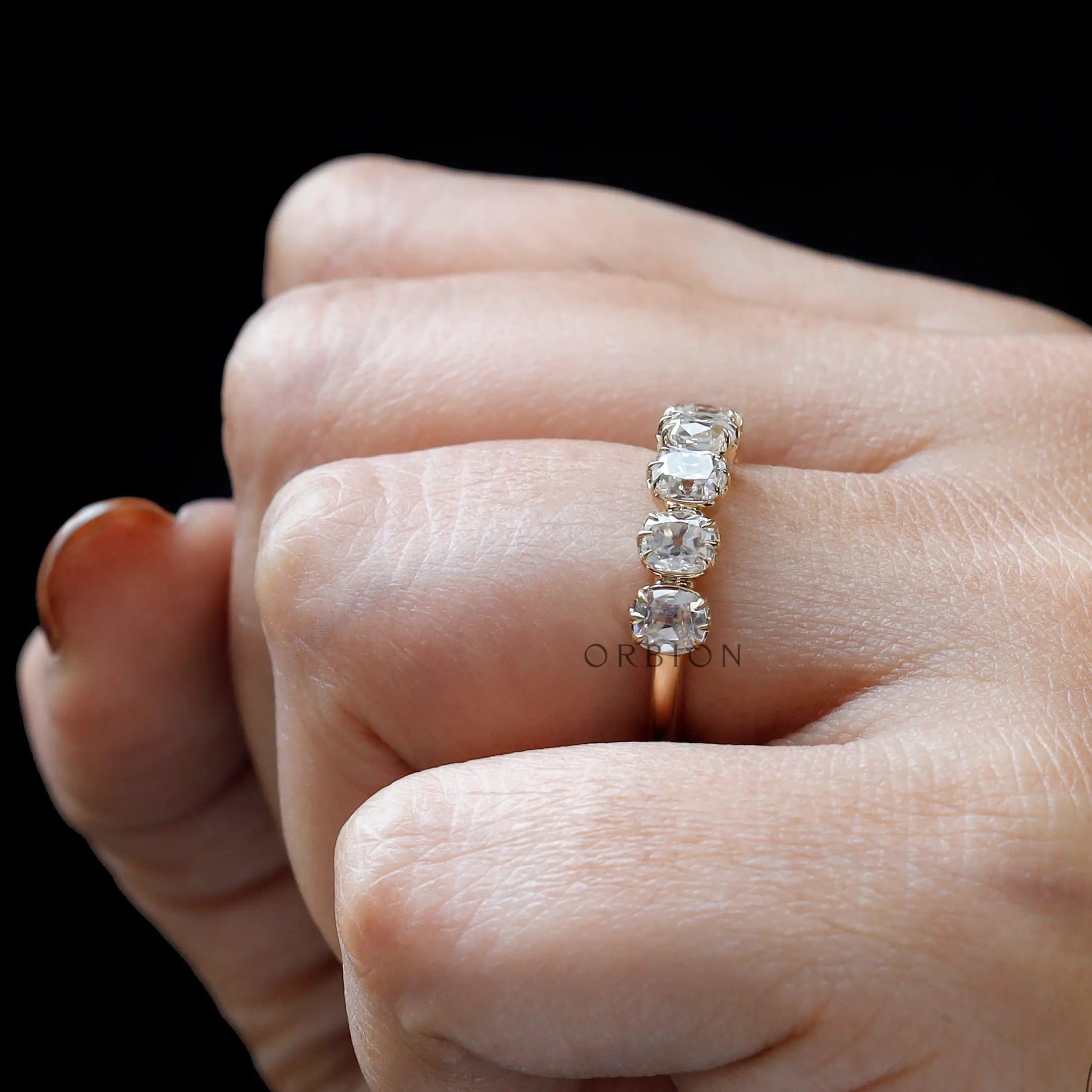 Close-up on-hand view of 7 moissanite stacking band showing vintage prongs