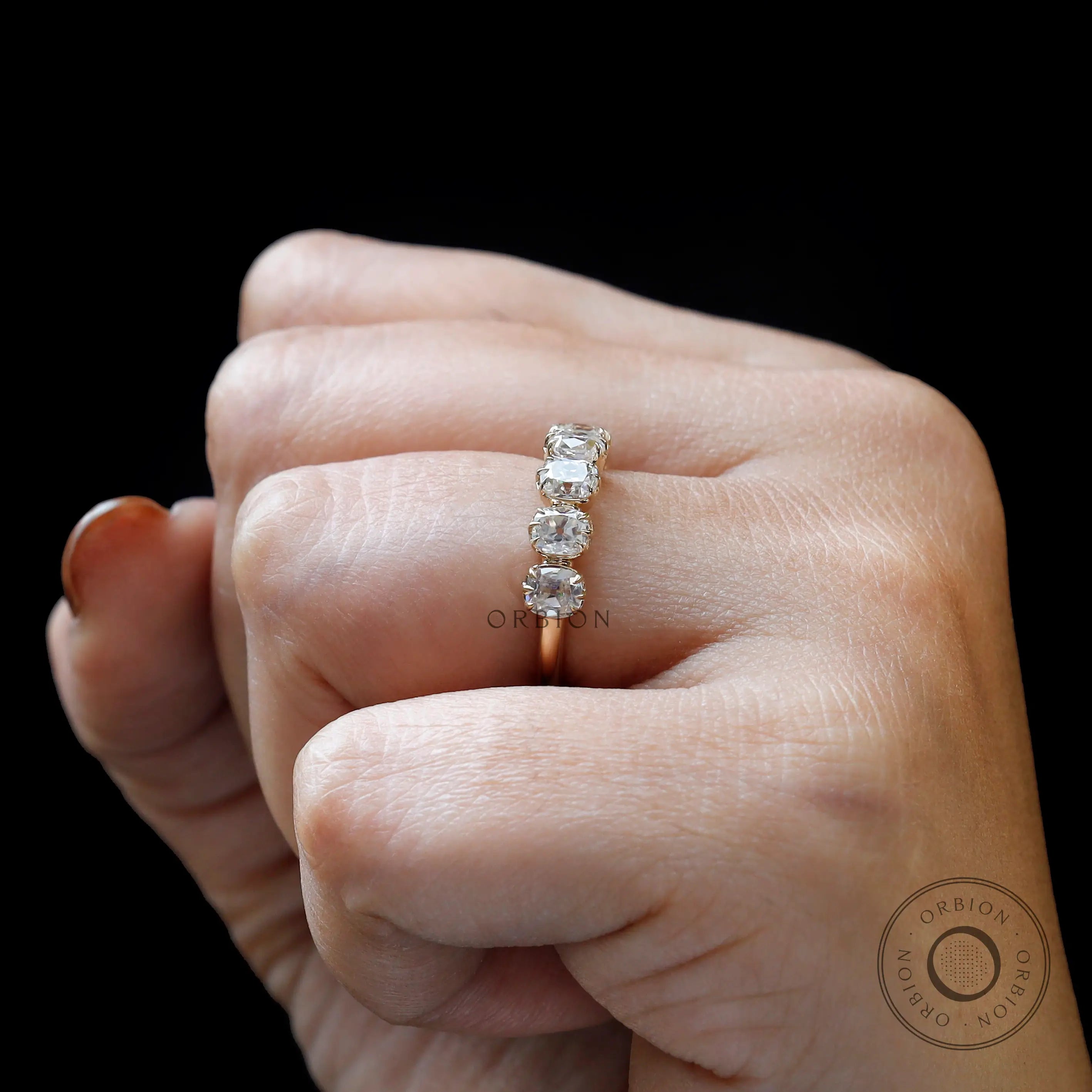 Close-up on-hand view of 7 moissanite stacking band showing vintage prongs
