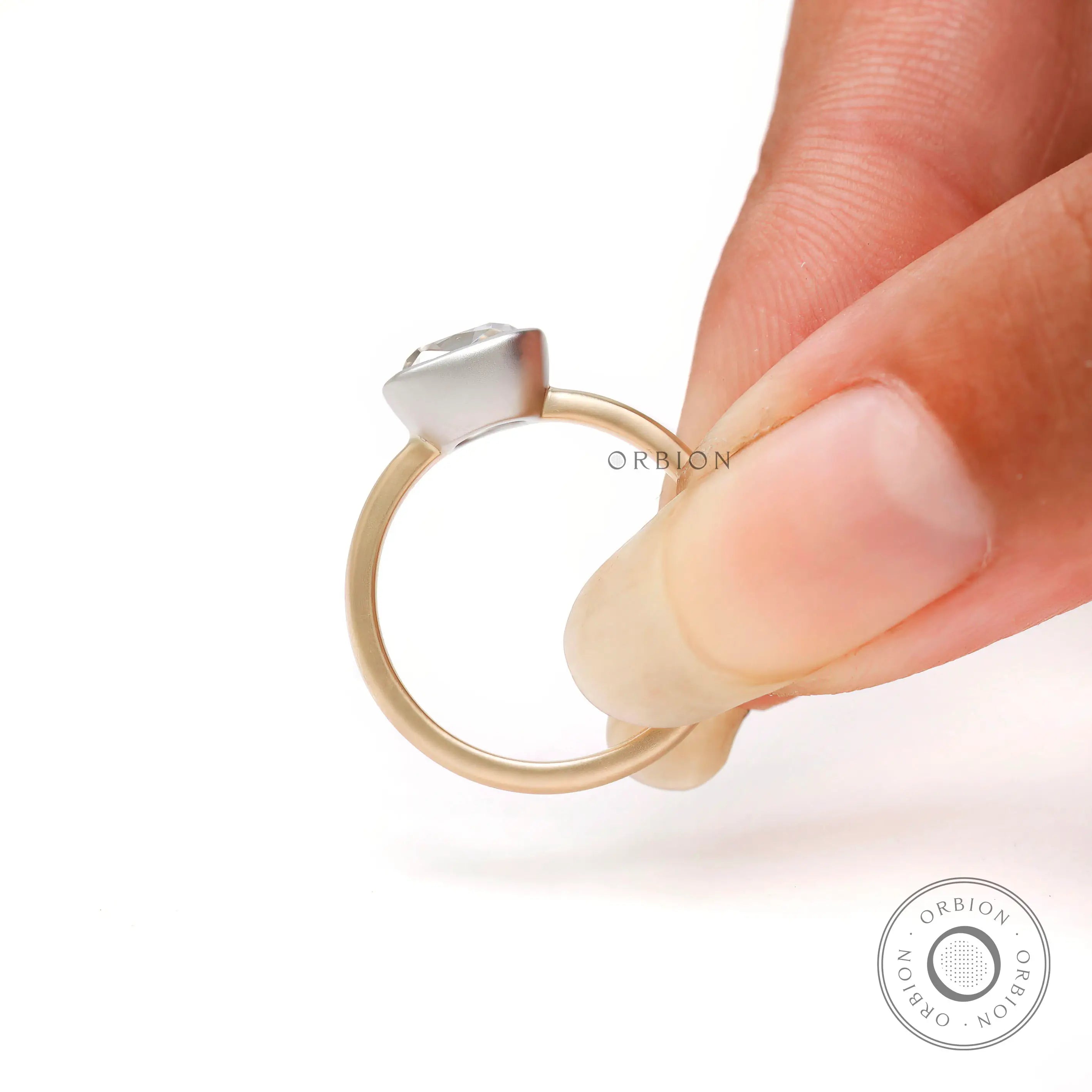 Yellow and white gold cushion bezel ring close up