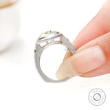 Matte band close up with bezel set side accent stone held on fingers