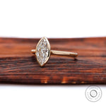 Angled view of marquise bezel solitaire cathedral ring in yellow gold