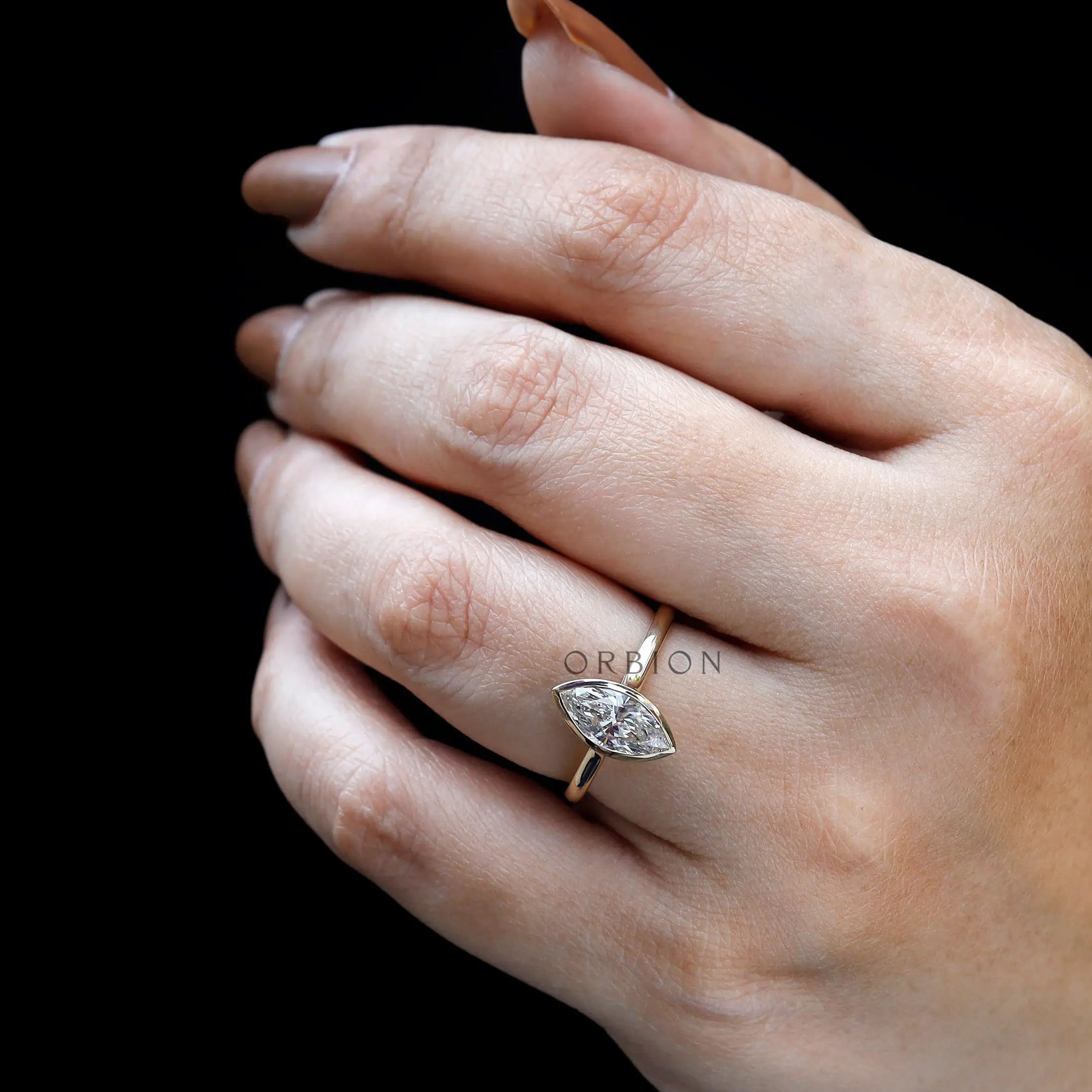Lifestyle on-hand view of marquise bezel cathedral engagement ring