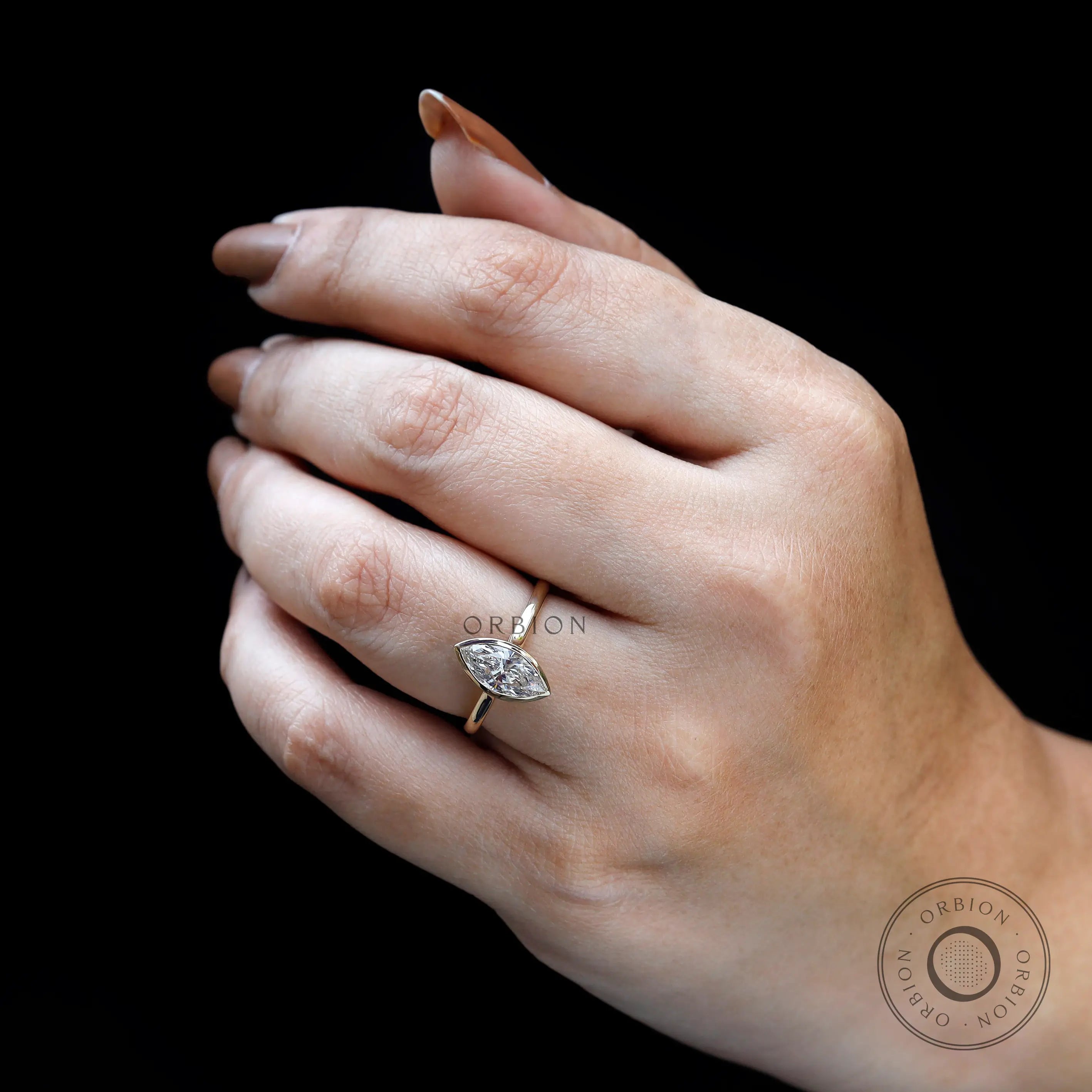 Lifestyle on-hand view of marquise bezel cathedral engagement ring