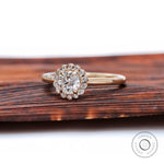 Angled view highlighting scalloped halo sparkle and slim polished yellow gold band.