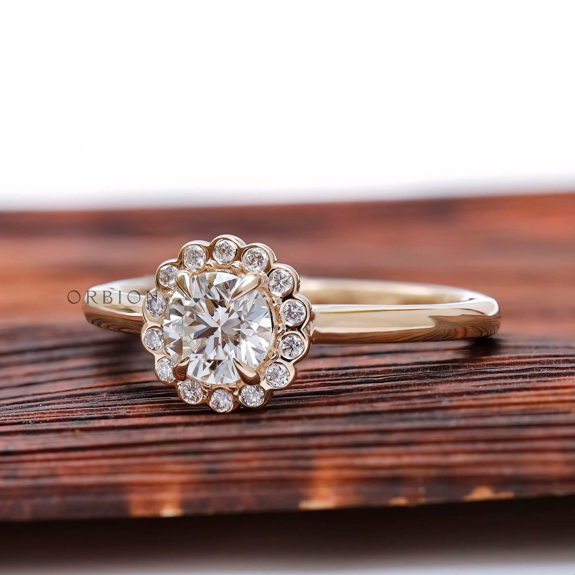 Angled view highlighting scalloped halo sparkle and slim polished yellow gold band.