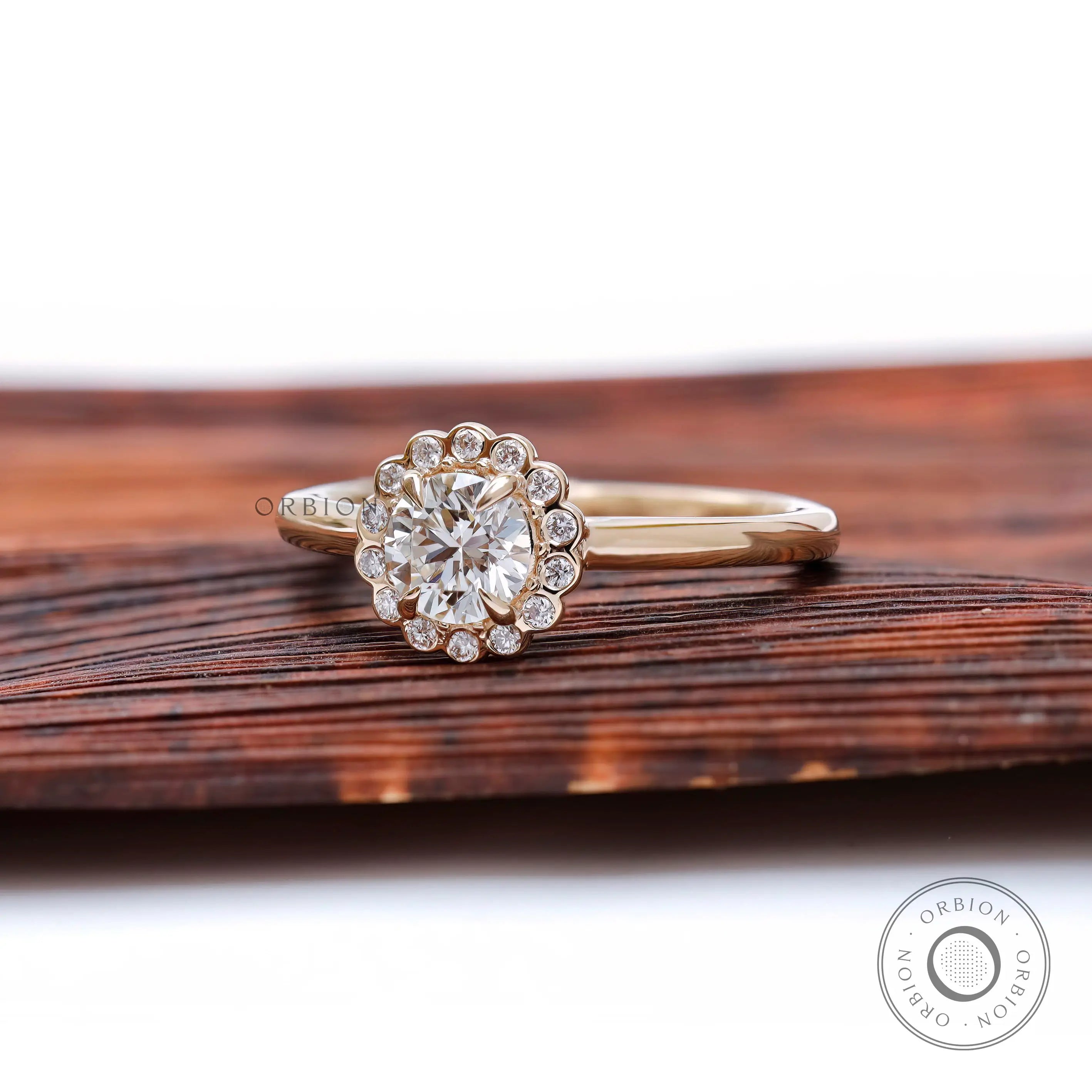 Angled view highlighting scalloped halo sparkle and slim polished yellow gold band.
