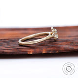 Side profile showing low-set cluster head and smooth yellow gold shank.