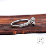 Side profile showing six-prong basket and pave half-eternity shoulders.