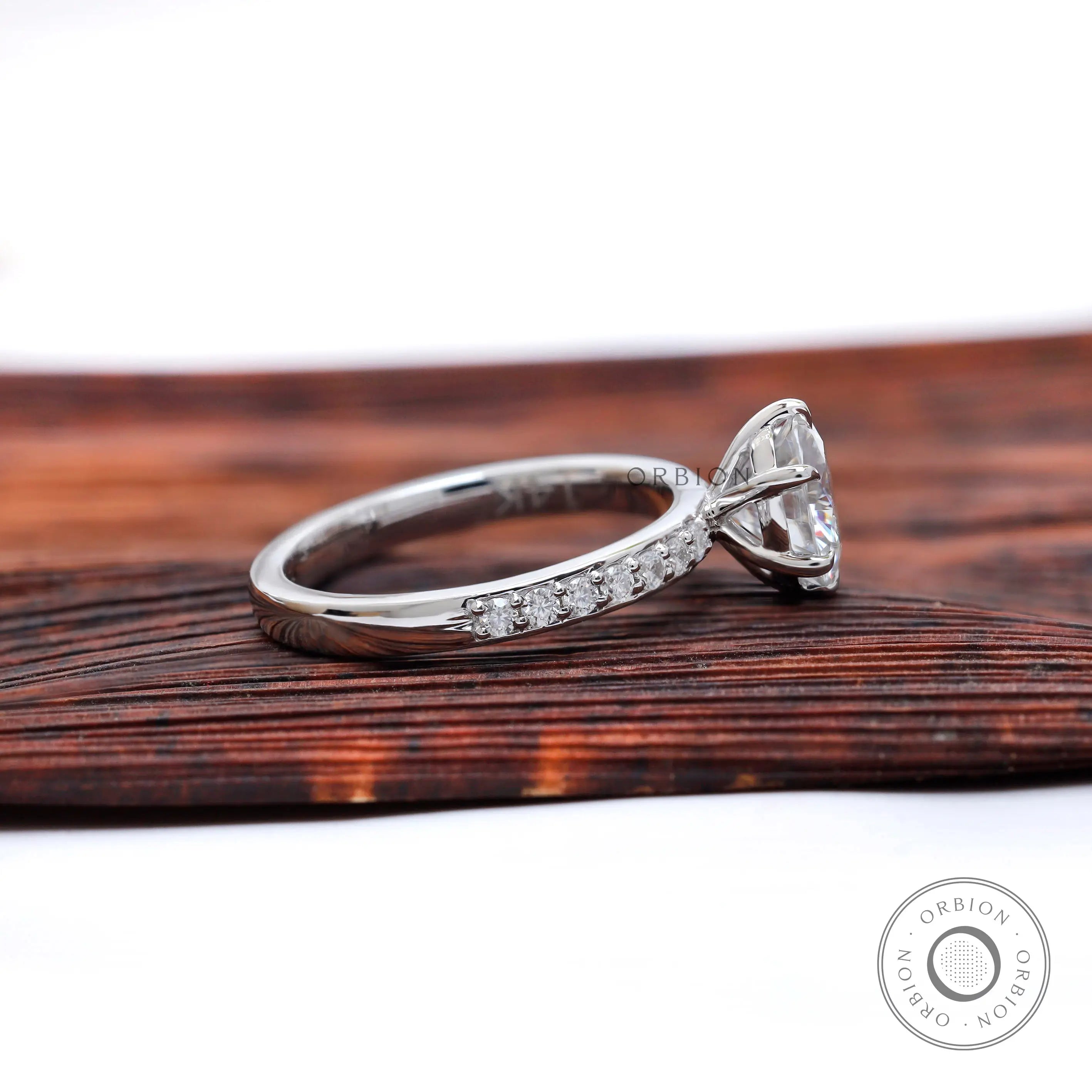 Side profile showing six-prong basket and pave half-eternity shoulders.