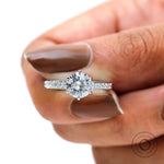 Top close-up of round moissanite center with pave accented band.