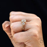 On hand view of three stone Georgian style ring in yellow gold.