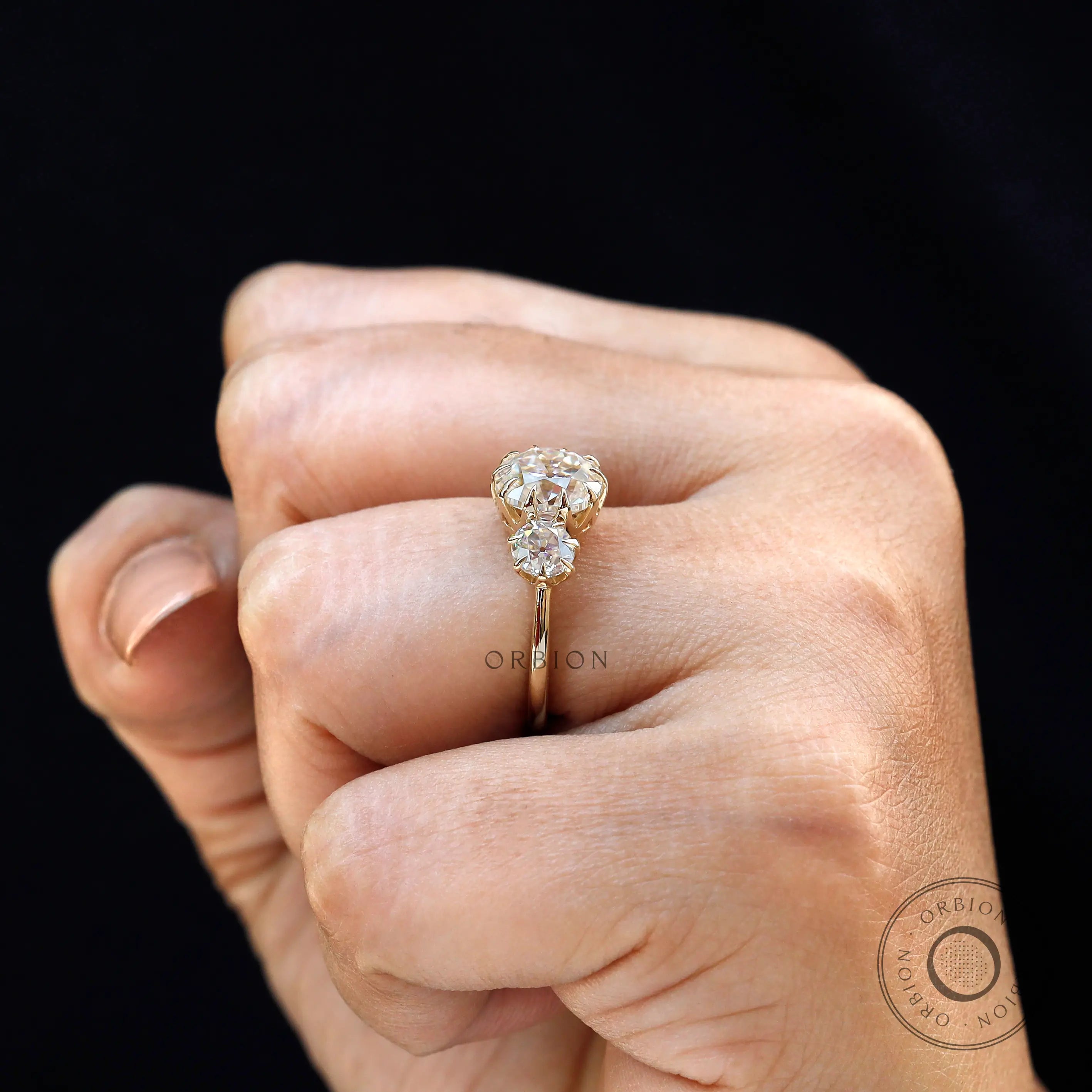 On hand view of three stone Georgian style ring in yellow gold.