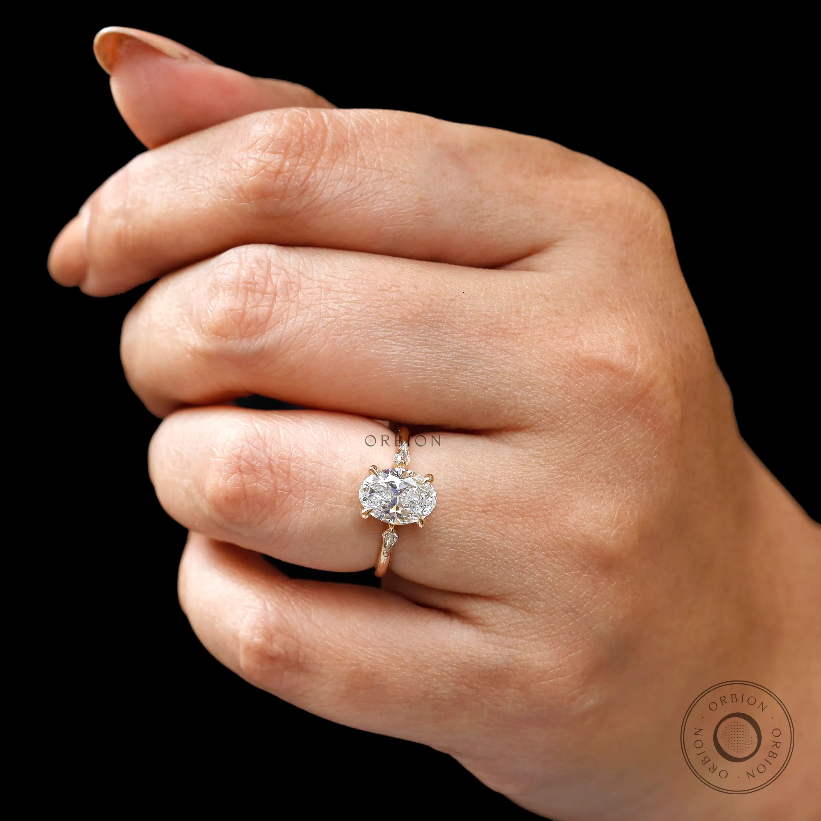 Close up of oval engagement ring with kite side stones and fine setting