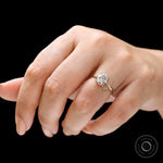 close up of three stone oval engagement ring on hand
