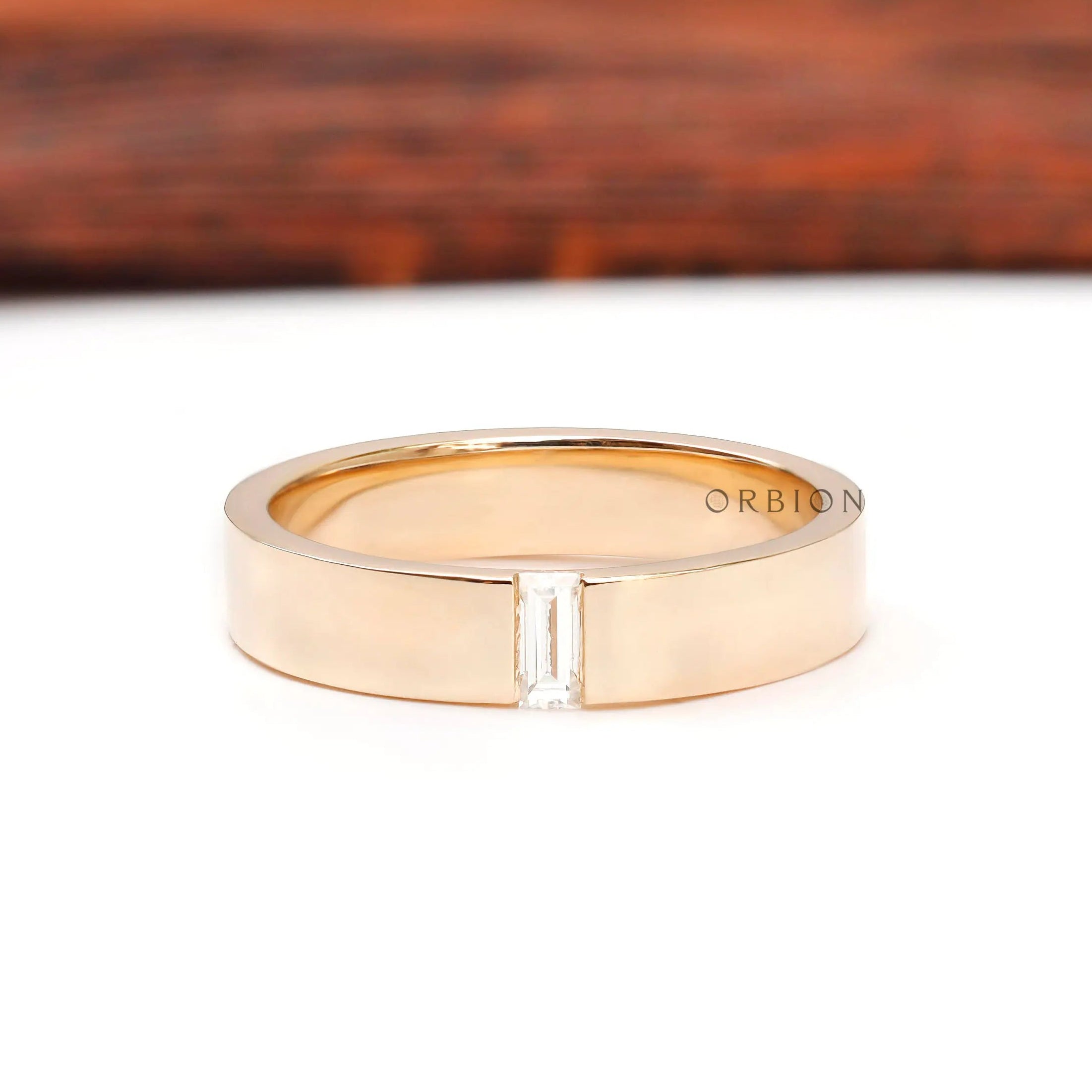 Front view of cigar wedding band with flush set baguette moissanite center.