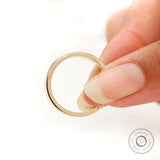 Edge detail of comfort fit band with flush set baguette, shown while held.