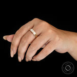 Lifestyle image of minimalist comfort fit wedding band with baguette moissanite worn on hand.