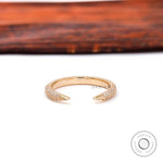 Tiny open pave diamond spacer band with claw tips displayed on white surface