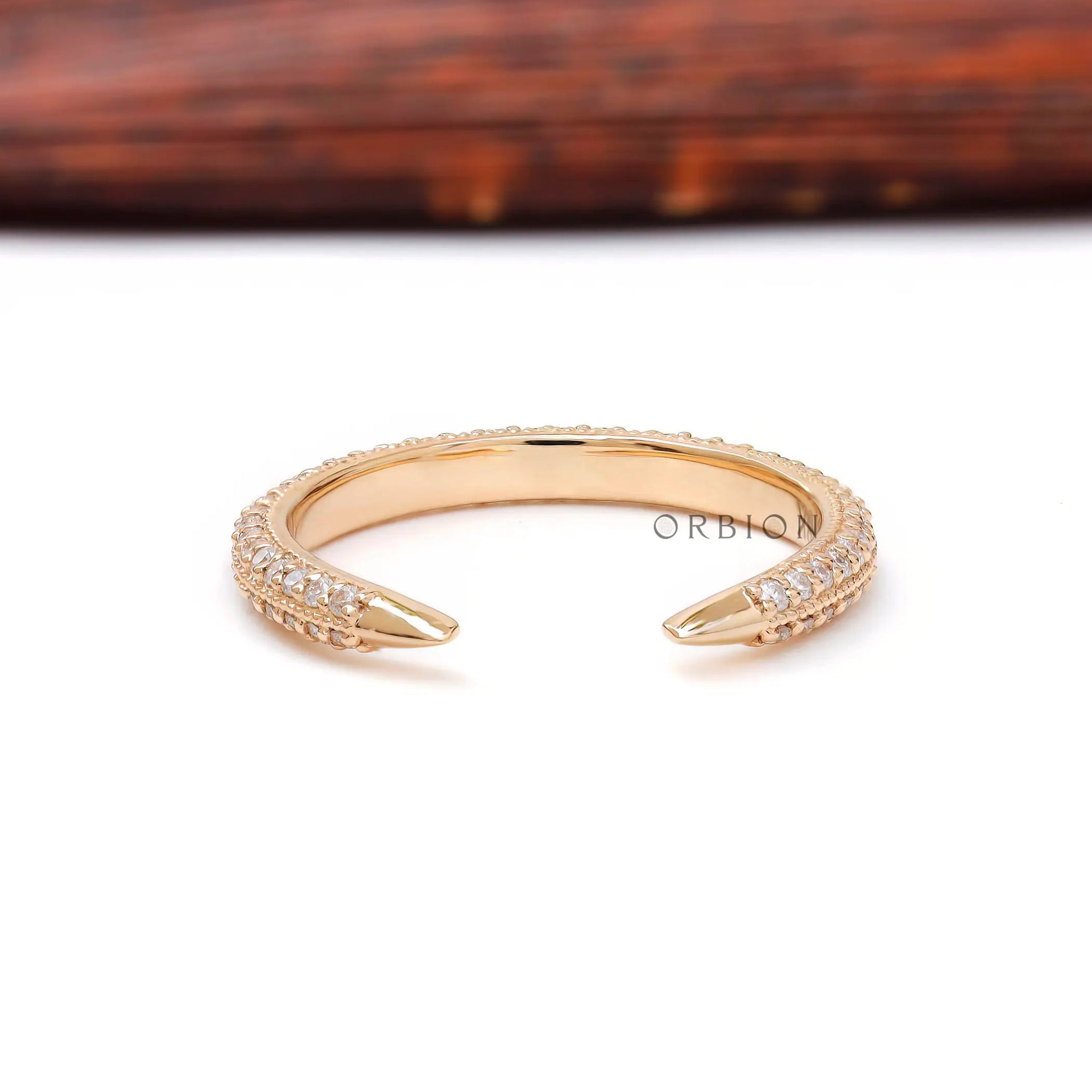 Tiny open pave diamond spacer band with claw tips displayed on white surface