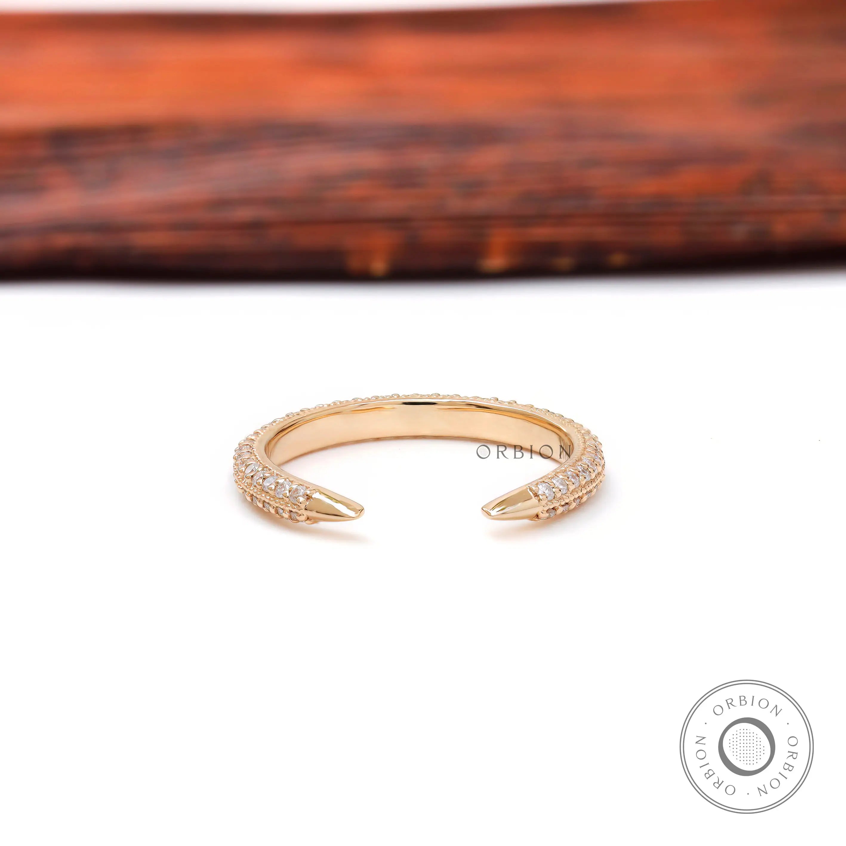 Tiny open pave diamond spacer band with claw tips displayed on white surface