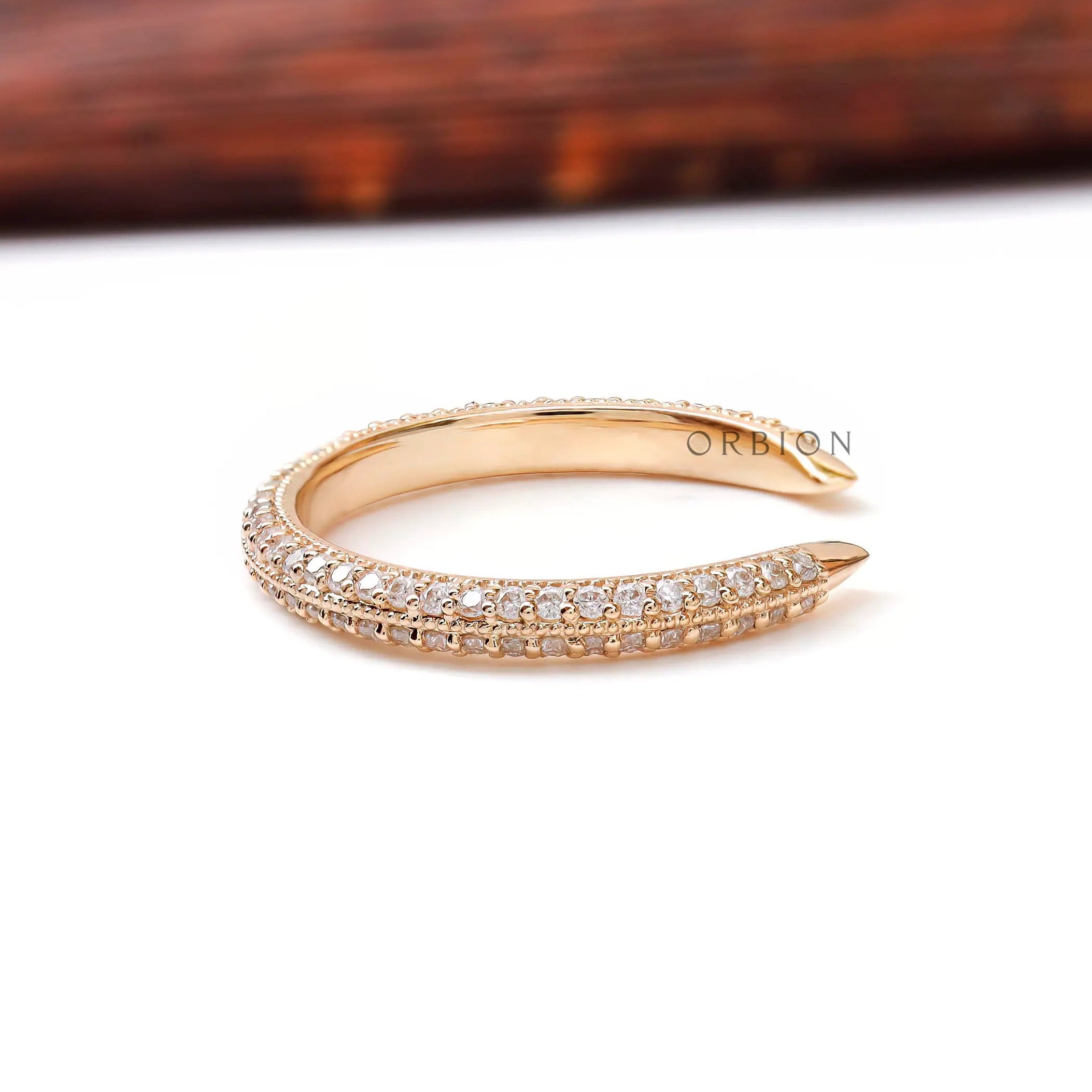 Side profile of slim open pave diamond band highlighting milgrain edges