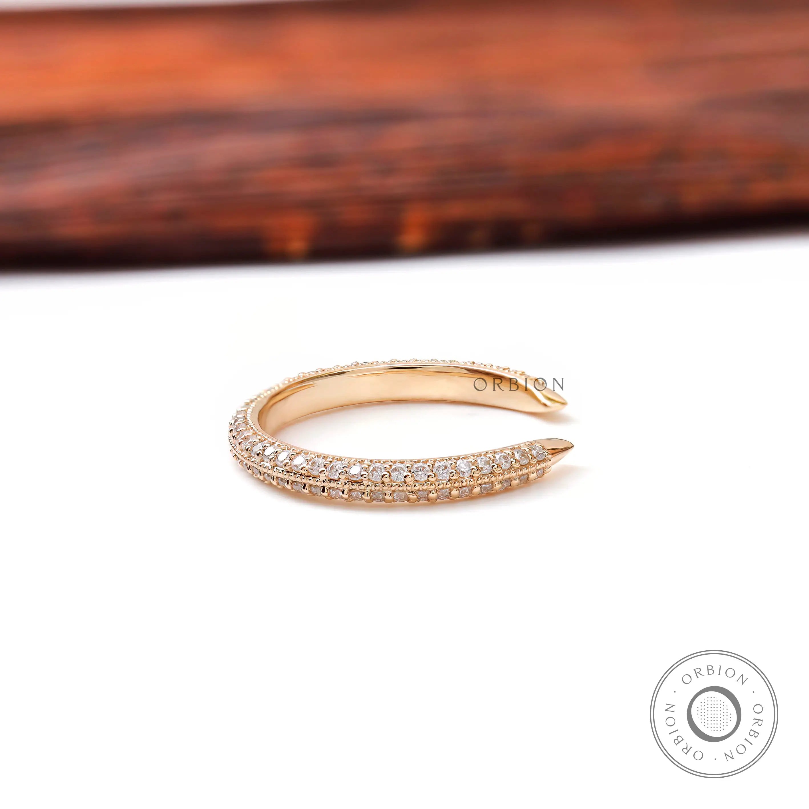 Side profile of slim open pave diamond band highlighting milgrain edges