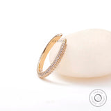 Open spacer pave band resting against soft stone background
