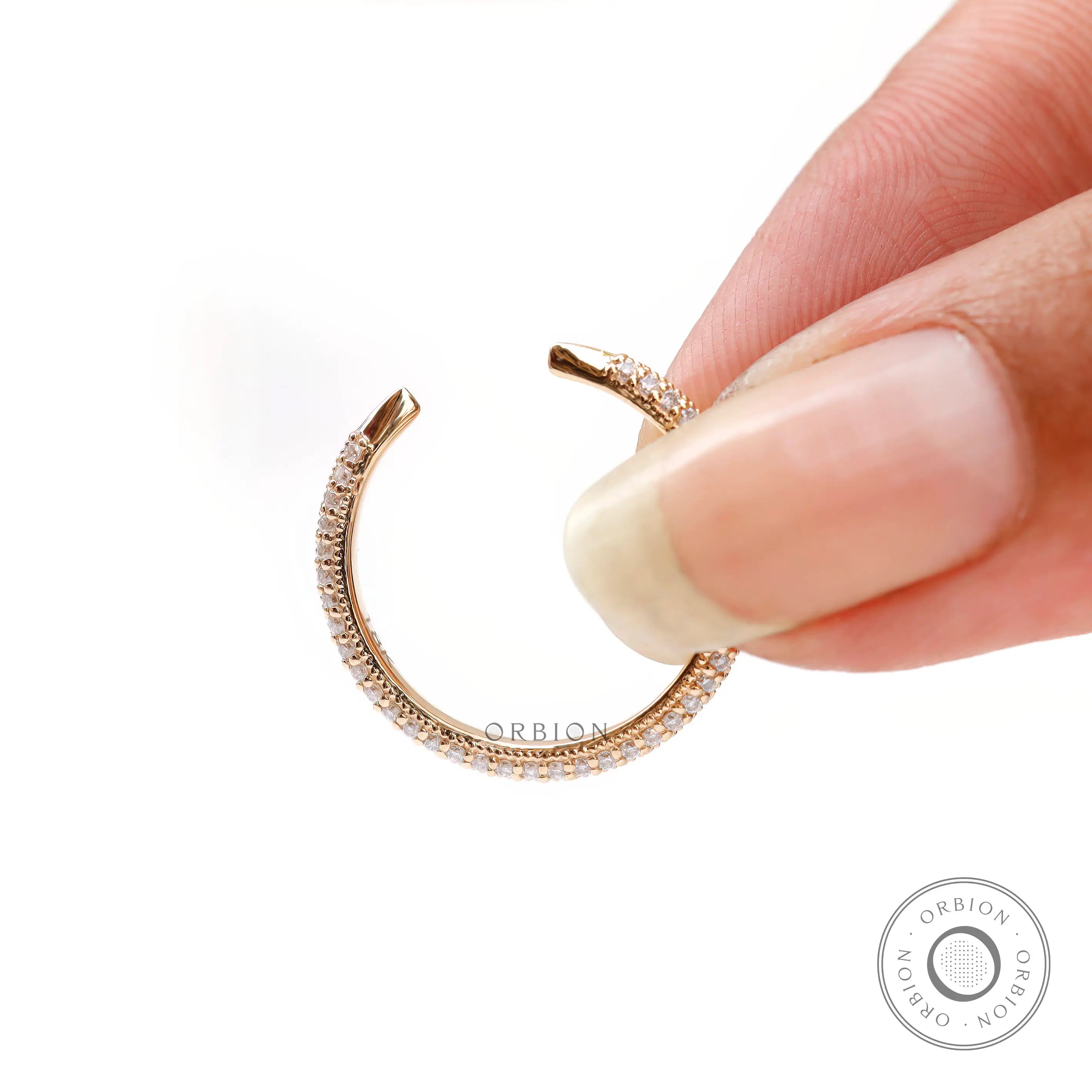 Tiny open claw pave band held between fingers to show delicate scale