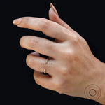 Dainty open claw pave band worn on finger against dark background