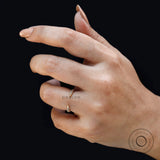 Dainty open claw pave band worn on finger against dark background