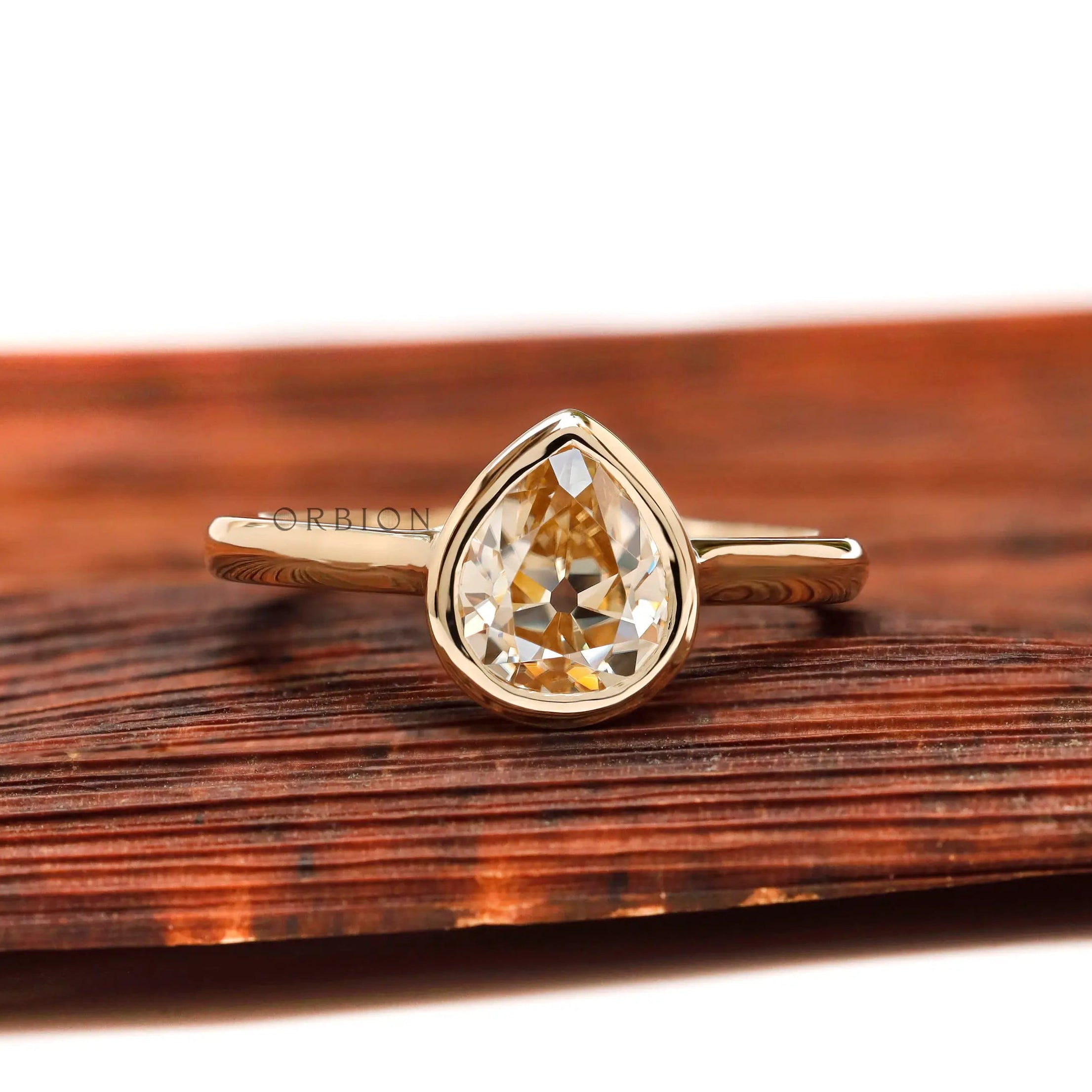 Pear Old Mine Cut light champagne moissanite bezel solitaire ring