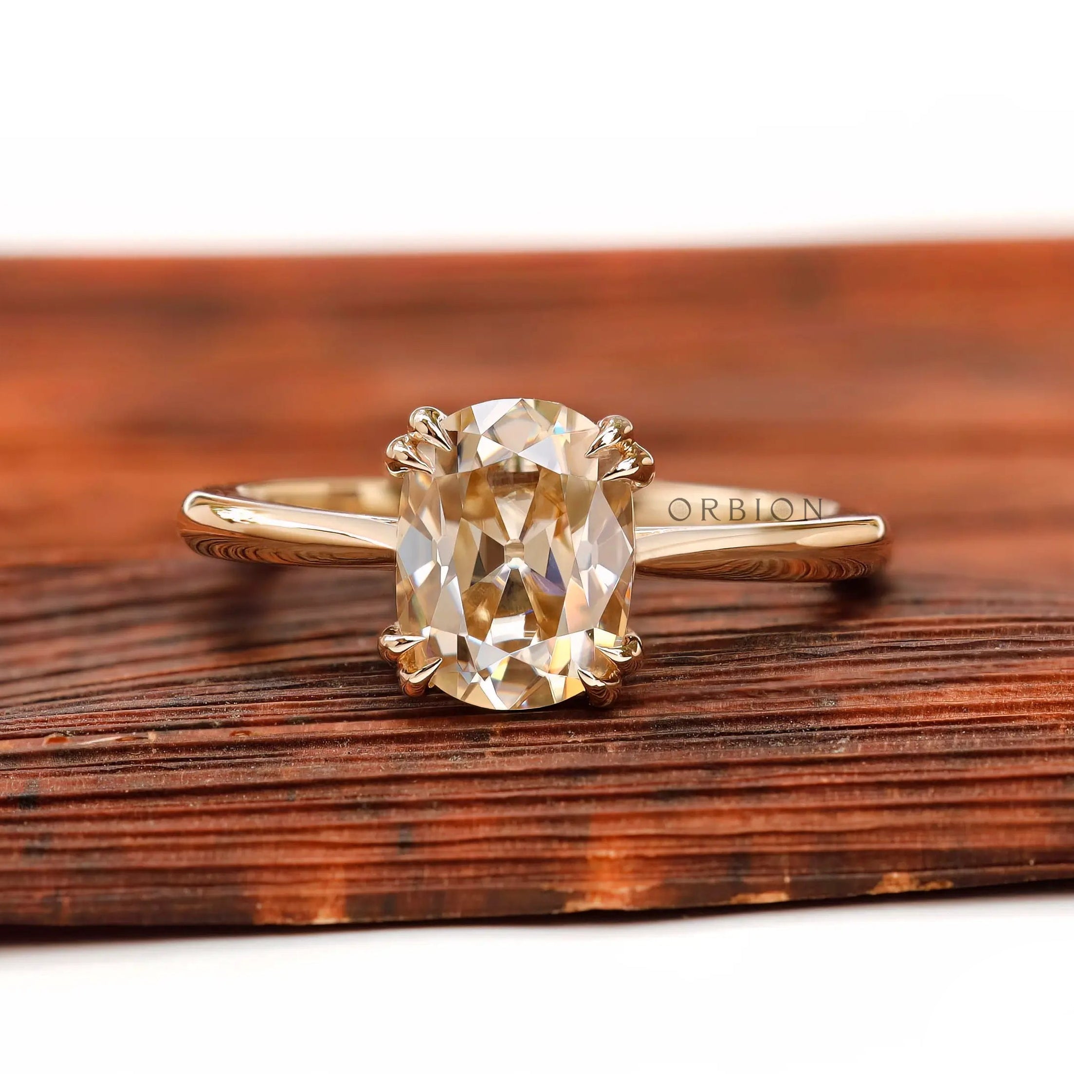 Front view of elongated cushion champagne moissanite cathedral solitaire ring