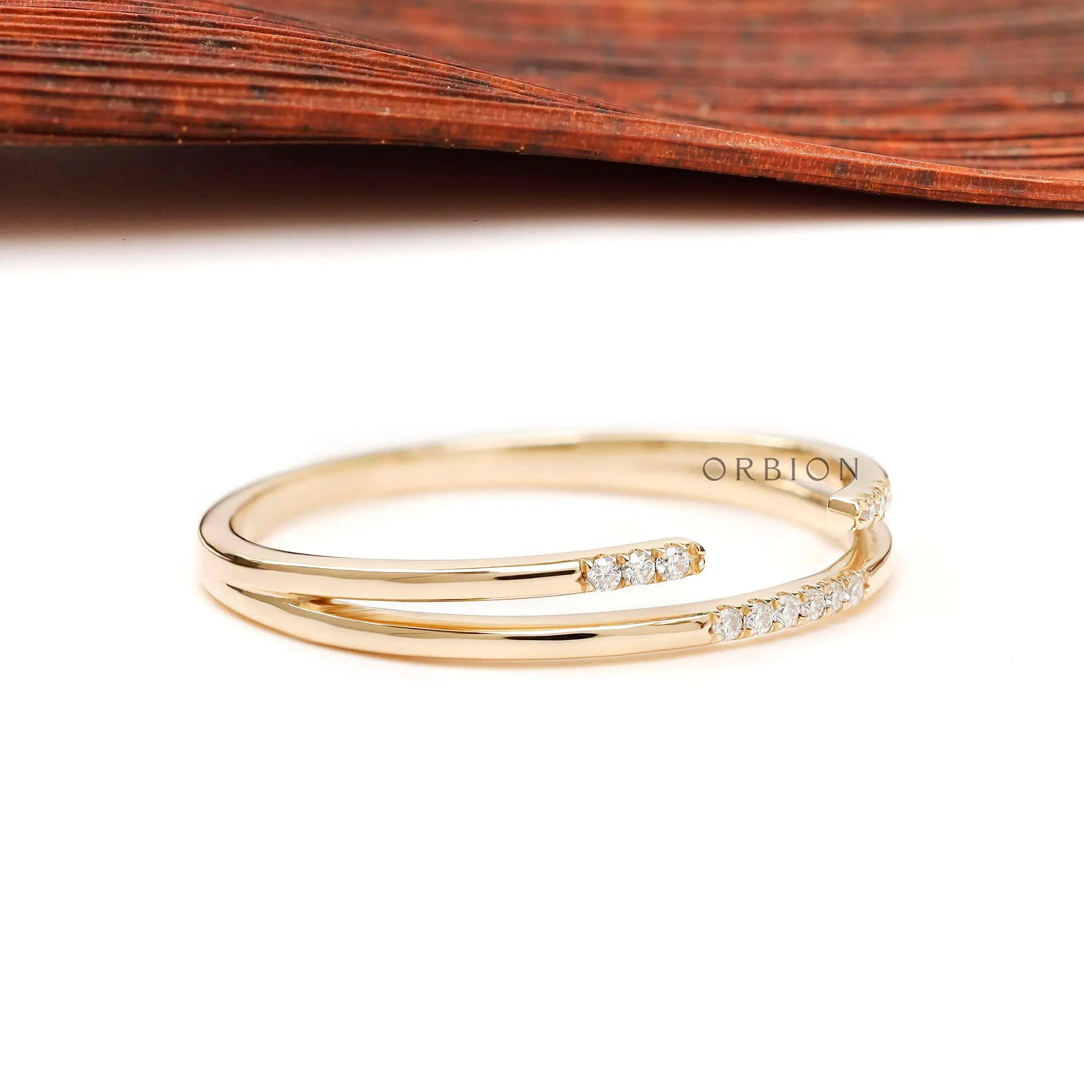 Angled view of dainty open cuff double band ring with pave stones