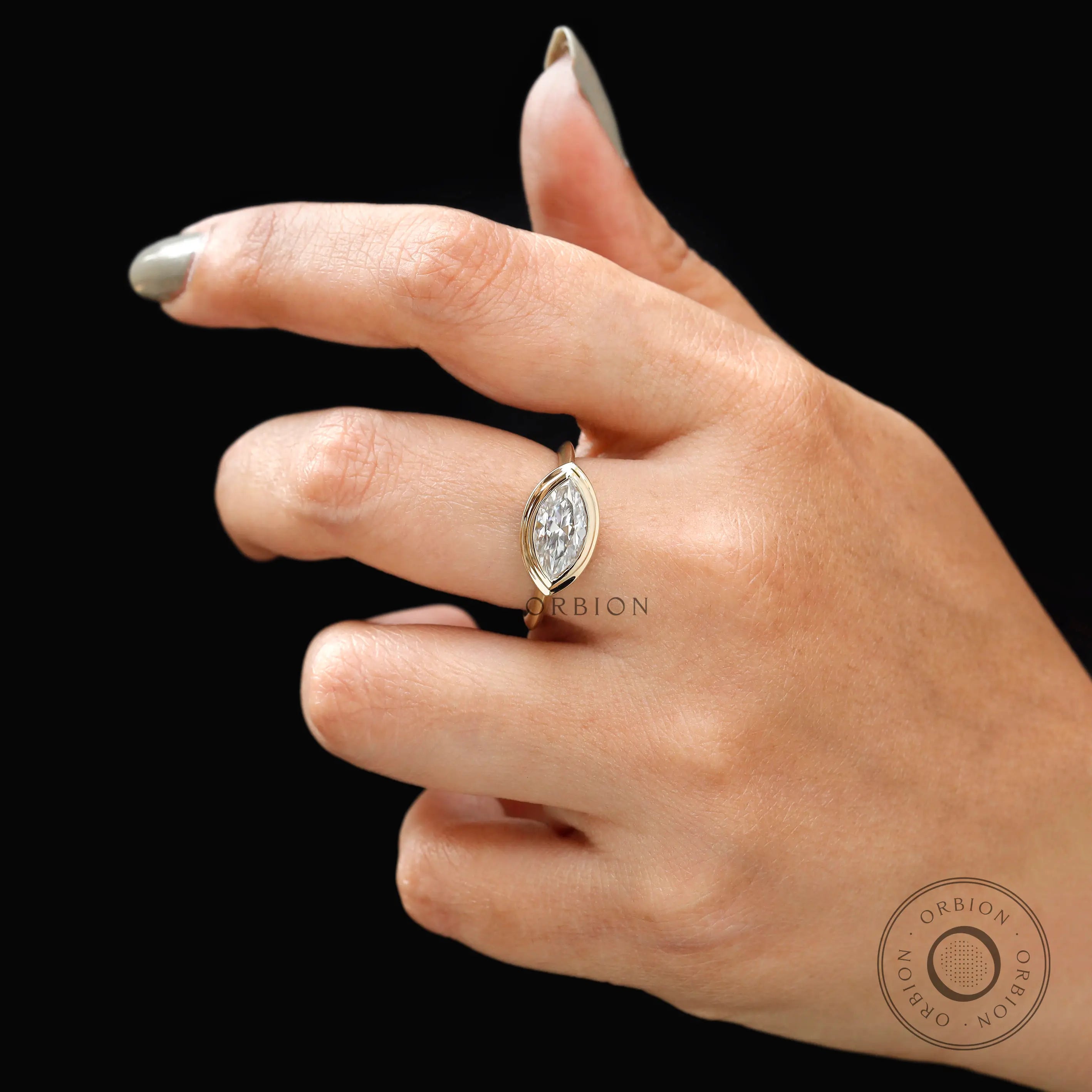 East west marquise lab diamond bezel engagement ring on hand