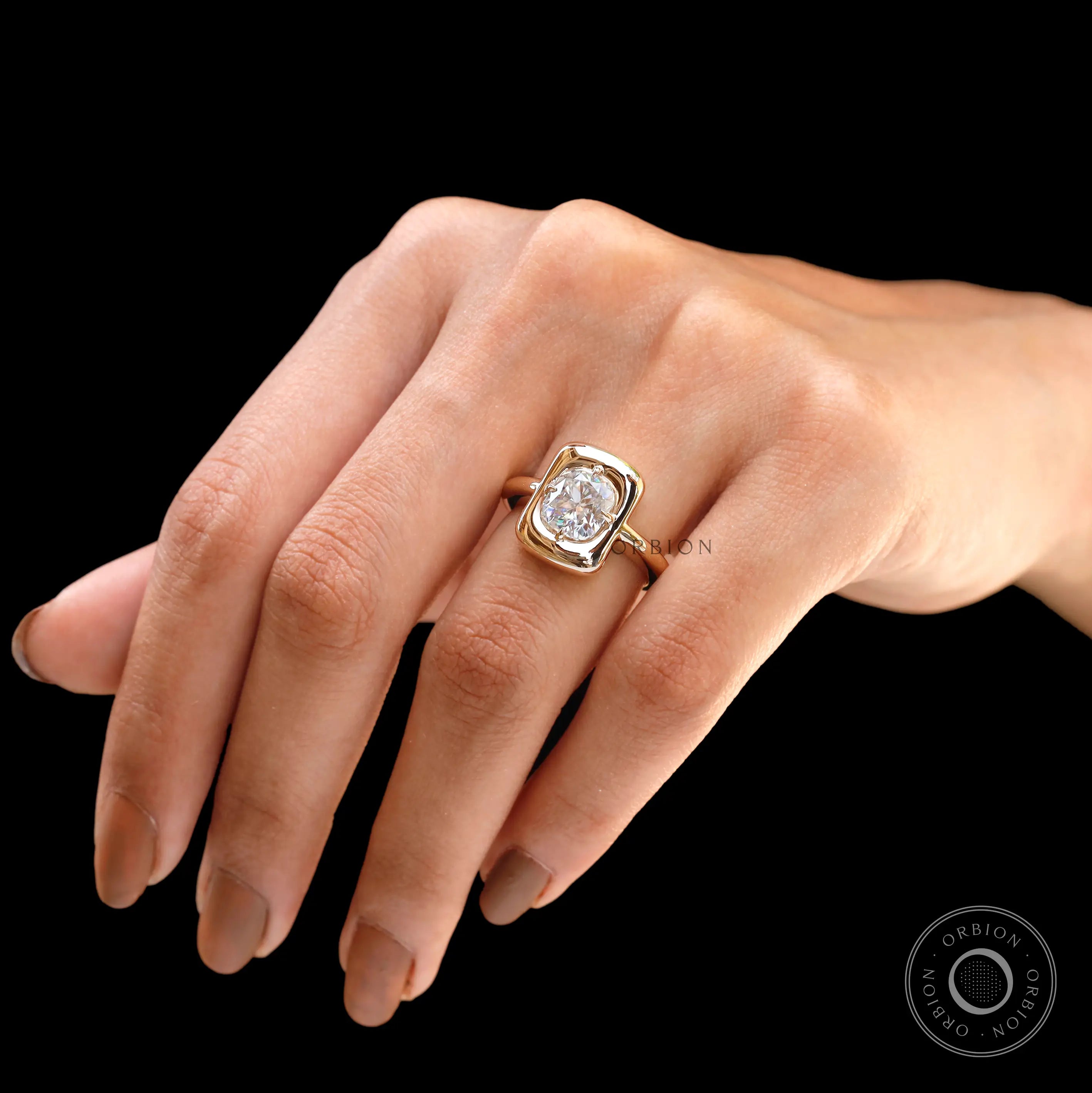 Cushion moissanite bezel ring held in hand