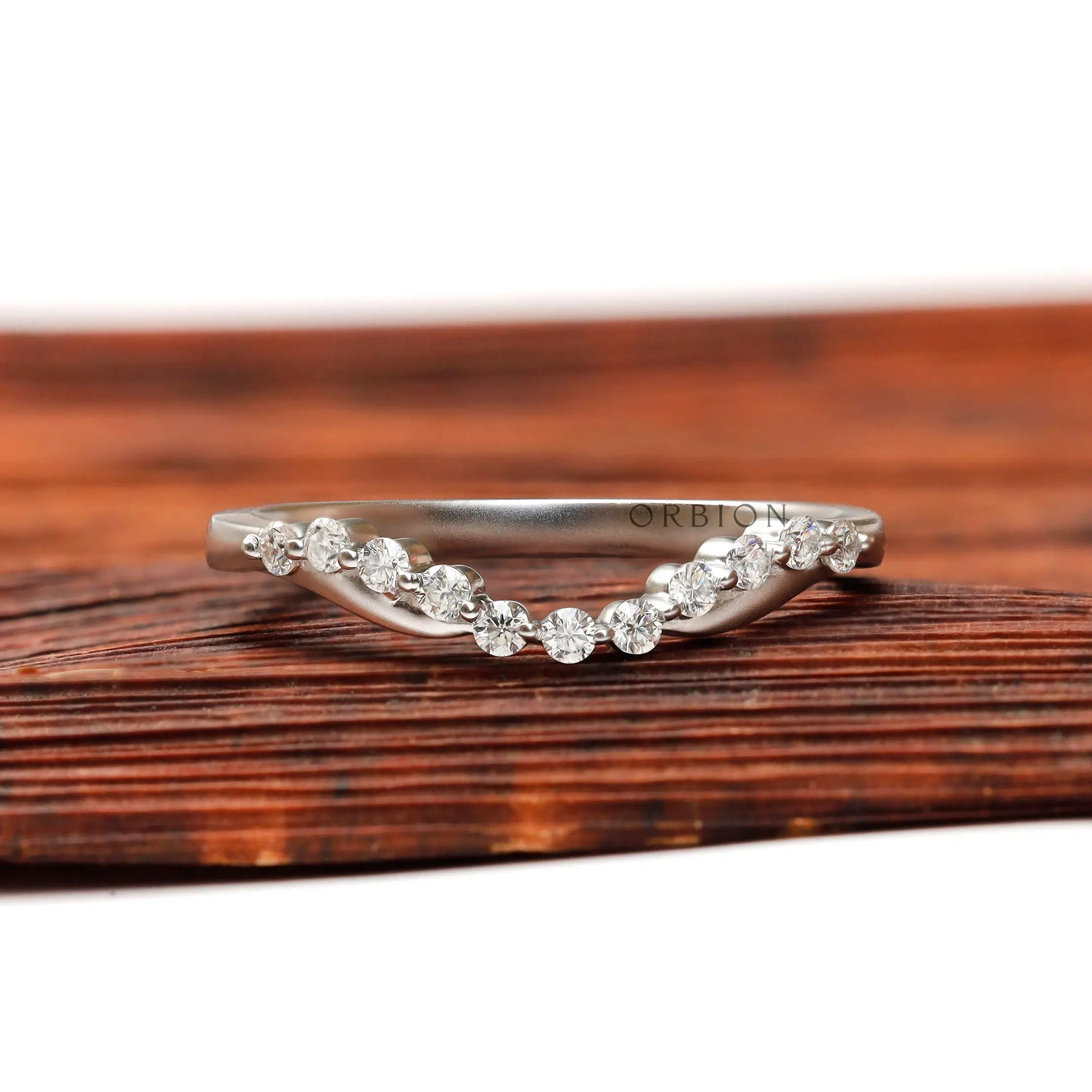 Front view of curved bubble prong half eternity diamond wedding band in matte white gold