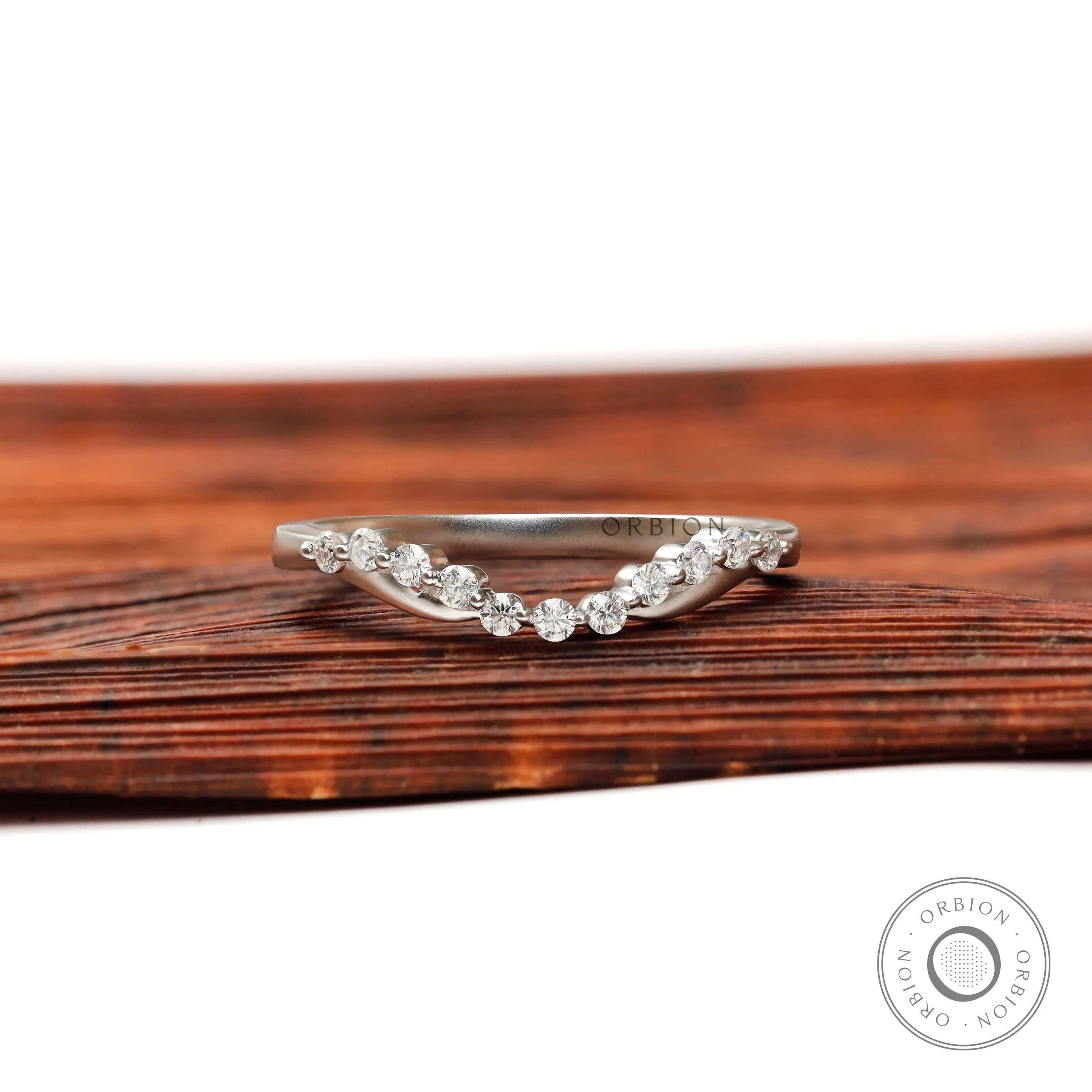 Front view of curved bubble prong half eternity diamond wedding band in matte white gold