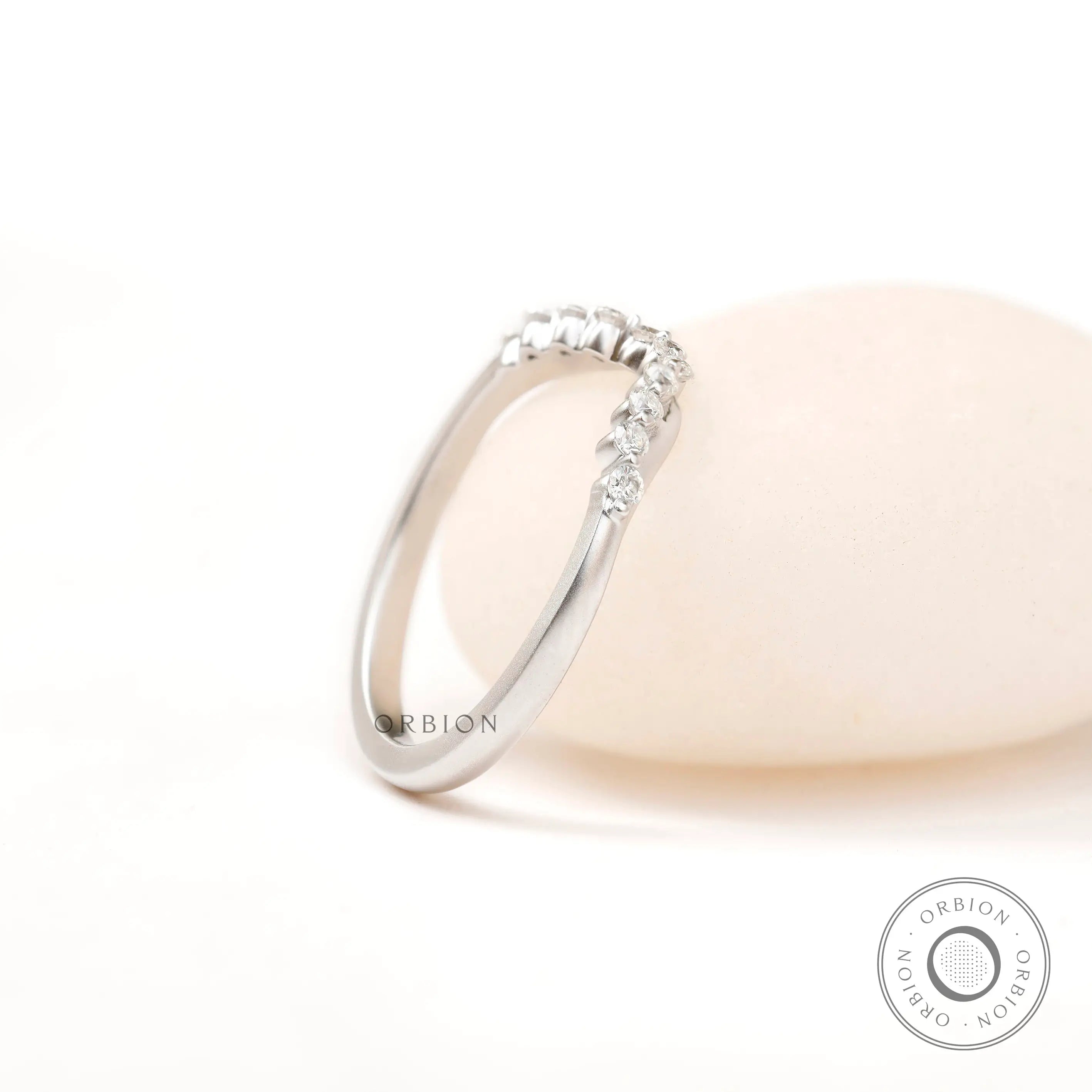 Side angled view highlighting matte white gold finish and diamond curve