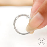 Close-up of bubble prong diamond details on curved wedding band