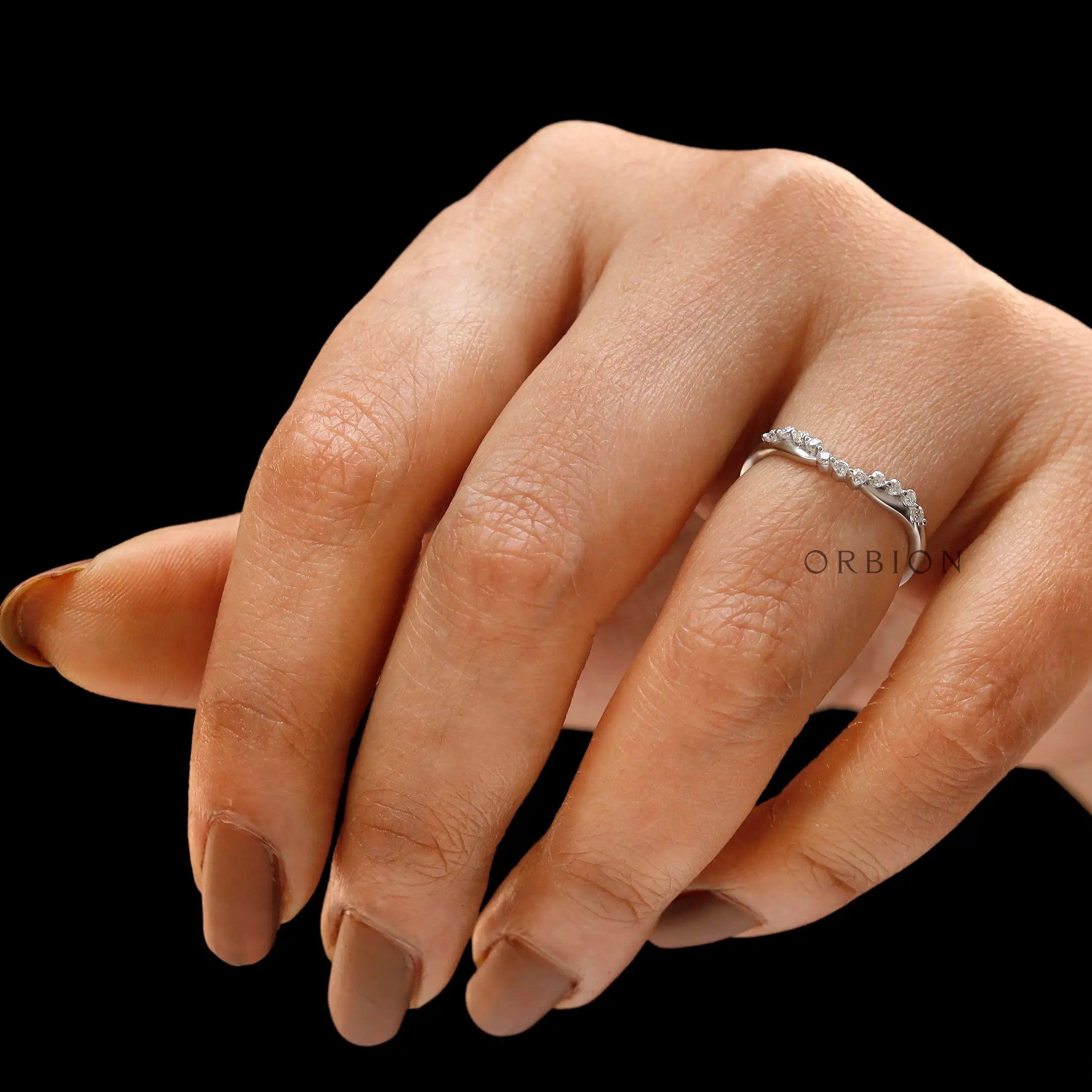 Curved half eternity diamond band worn on finger showing contour fit