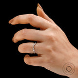Hand wearing curved bubble prong wedding band on black background