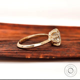 Side profile of round moissanite solitaire engagement ring in yellow gold