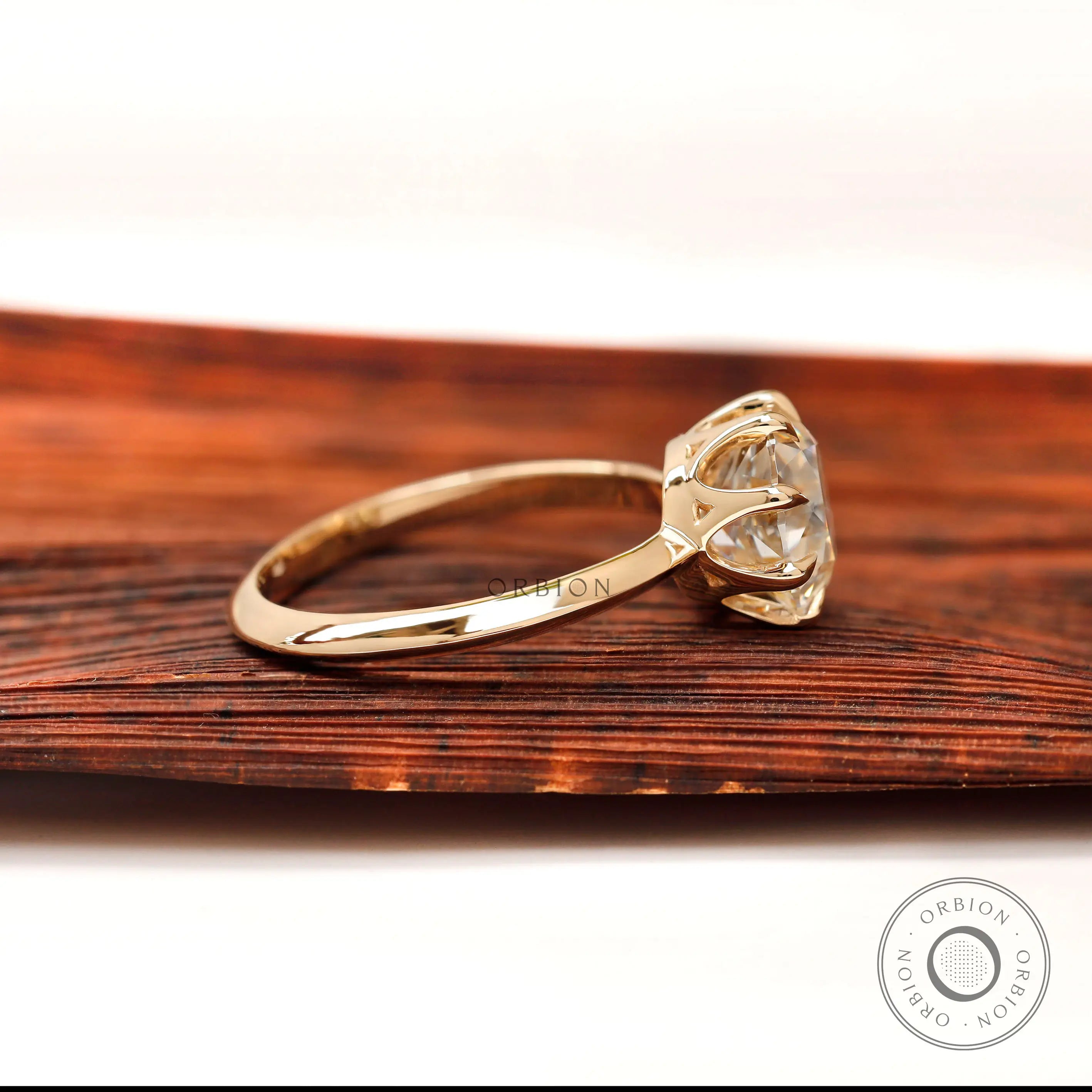 Side profile of round moissanite solitaire engagement ring in yellow gold