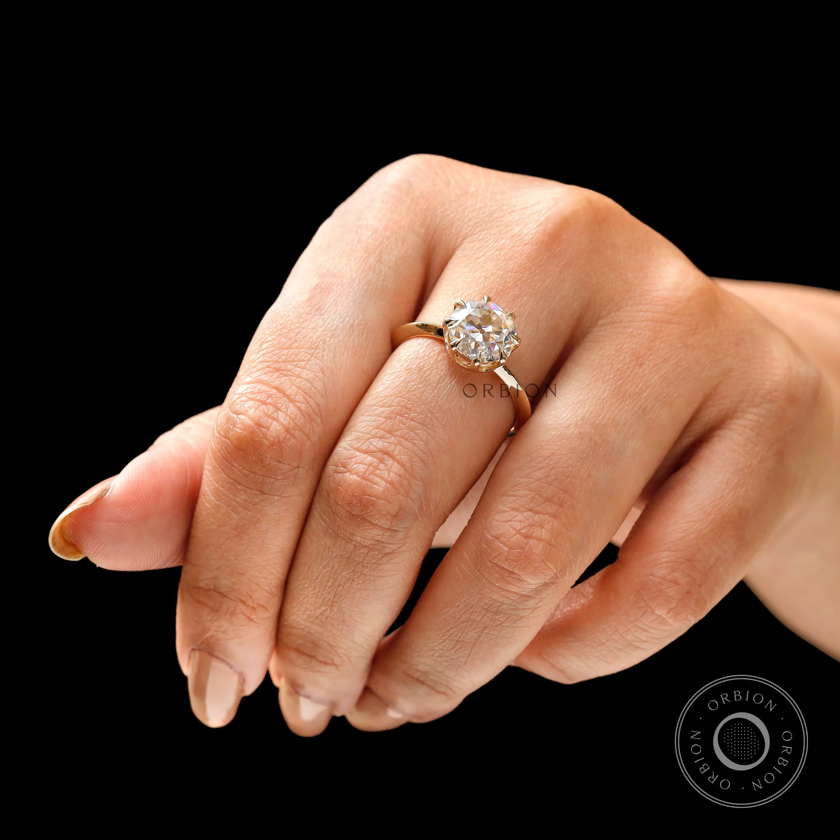 Elegant round moissanite engagement ring worn on hand