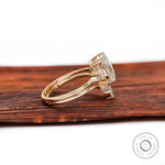 Side view of oval moissanite cluster ring and curved wedding band