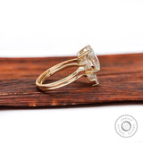 Side view of oval moissanite cluster ring and curved wedding band